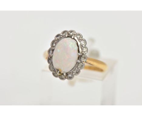 A 9CT GOLD OPAL AND DIAMOND CLUSTER RING, of an oval form, centring on an oval cut opal cabochon, showing flashes of red, blu