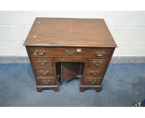 A GEORGIAN STYLE MAHOGANY KNEE HOLE DESK, with a single long drawer, over two banks of three drawers flanking a single cupboa