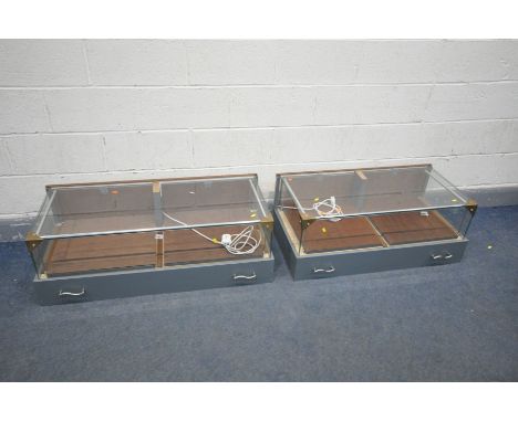 A PAIR OF TABLE DISPLAY CABINETS, with twin sliding trays/doors, led lighting, and grey painted plinths, width 97cm x depth 4