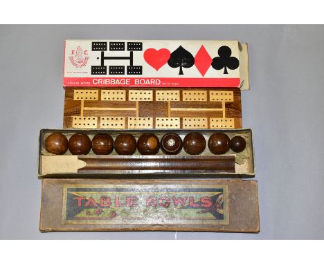 A BOXED SET OF TABLE BOWLS AND A BOXED CRIBBAGE BOARD, the early twentieth century Table Bowls appear complete with instructi