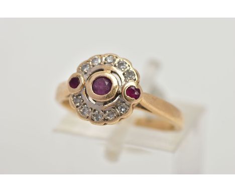 A 15CT GOLD, DIAMOND AND RUBY CLUSTER RING, of a circular design, centring on a circular cut collet mounted ruby, flanked wit