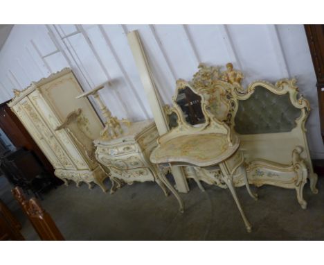 A Rococo Revival painted cream bedroom suite, comprising armoire, commode, dressing table (lacking drawers), tripod table, do