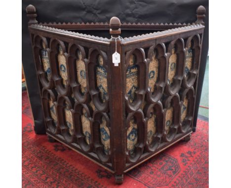 A Gothic Revival oak stick stand, the triangular superstructure crested by three turned finials interspersed with three rows 