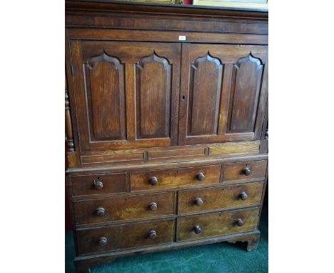 A George III Welsh oak housekeeper's press cupboard, outswept cornice above a pair of rectangular doors, each with two raised
