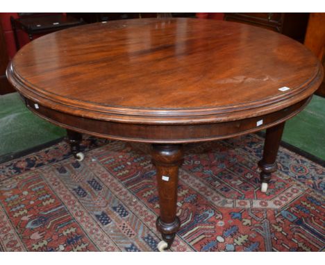 A 19th century mahogany circular extending dining table, moulded top, turned tapered legs, ceramic casters, void of leaves, 1