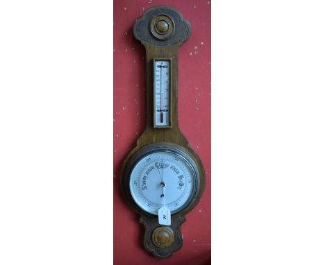 A carved oak aneroid barometer thermometer, carved top and foot, silvered scale, approx 66cm high