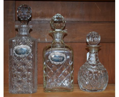 A cut glass liqueur decanter, silver collar; a large cut glass Whisky decanter with Whisky label; a Victorian glass decanter 