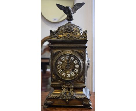 A 20th century brass mantel clock, 8.5cm dial embossed with a fluted urn and scrolling foliage, bold Arabic numerals, twin wi