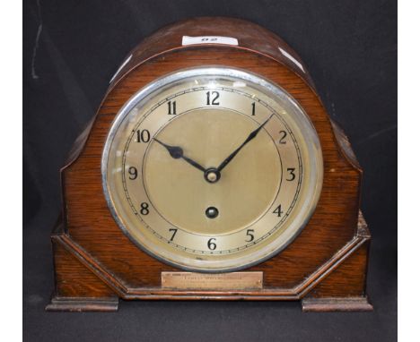 An oak cased mantel clock, silvered dial, Arabic numerals, silver presentation plaque