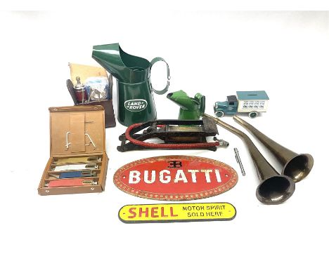 Bugatti cast iron sign with a red background, Shell Oil cast iron sign with gold background, together with Land Rover oil can