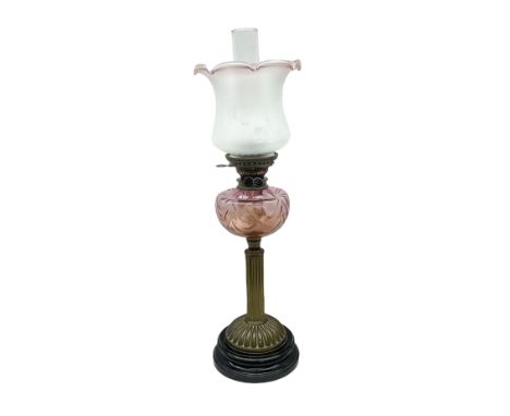 Victorian table oil lamp with black glazed stepped circular base, reeded brass column, moulded pink glass reservoir, duplex b