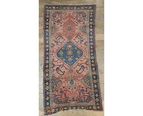 A Persian salmon pink ground rug, 202 x 98 cm