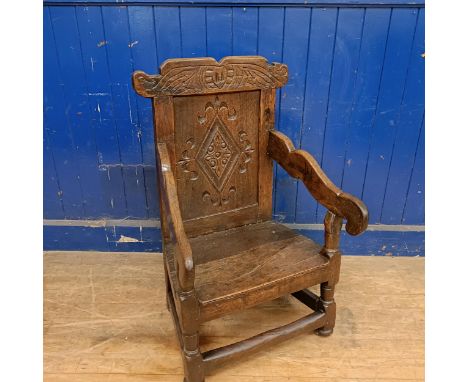 An oak Wainscot type armchair, with a carved back