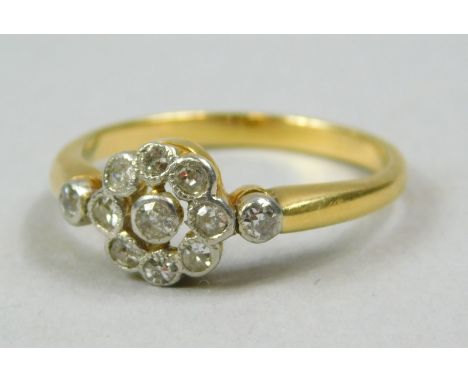 A diamond dress ring, in floral design set with tiny diamonds, with tiny diamond to each shoulder, yellow metal, unmarked, 2.