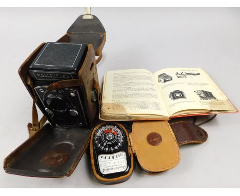 A Rolleiflex reflex camera, in a leather case, number 990128, with instructions and a Weston Master III light meter