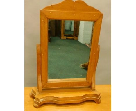 A pine dressing table mirror, the rectangular plate with a shaped crest on serpentine base, with bracket feet, 39cm wide