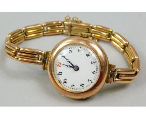A 9ct gold wristwatch, with circular watch head, with white enamel dial, with blue hands, on an expanding bracelet, stamped 9