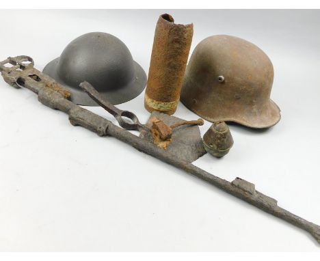 A collection of First World War memorabilia, to include a German helmet, part of a rifle, a shell, axe, tin hat etc., all in 