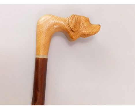 A modern walking stick, the handle carved in the form of a Labrador type dog.