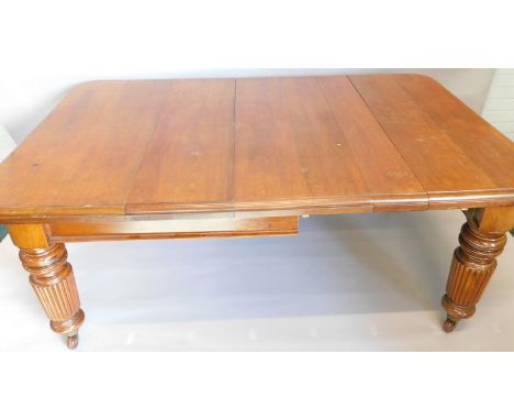 A Victorian mahogany extending dining table, the rectangular top with a moulded edge, on large turned and reeded legs on cera