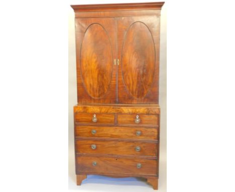 A 19thC mahogany cabinet, with a moulded cornice above two oval panelled doors, enclosing shelves, the base with two short an