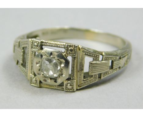 A diamond set dress ring, in the Art Deco style, with central old cut diamond approx 0.11cts, with pierced design head, white