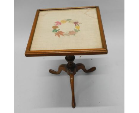 An early 20thC mahogany occasional table, the square top with an embroidered linen panel, on turned column, tripod base, 33cm