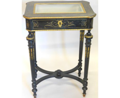 A 19thC ebonised and parcel gilt display table, the hinged top with a central bevelled glass plate, enclosing a velvet padded