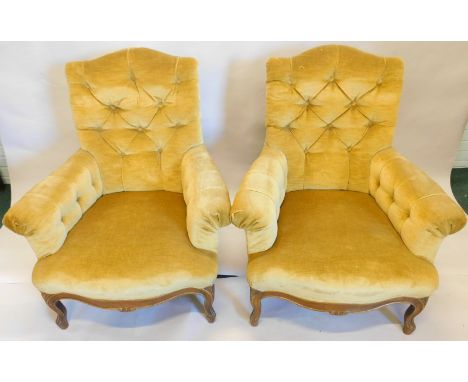 A pair of Continental walnut armchairs, each with a button back, arm rest and padded seat, on cabriole legs, possibly Danish.