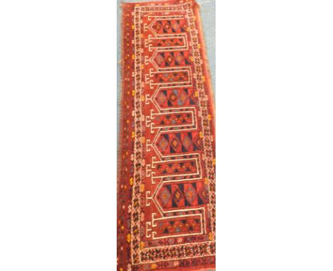 A Turkoman narrow runner, with a design of stylised towers, within multiple borders, 158cm x 49cm.