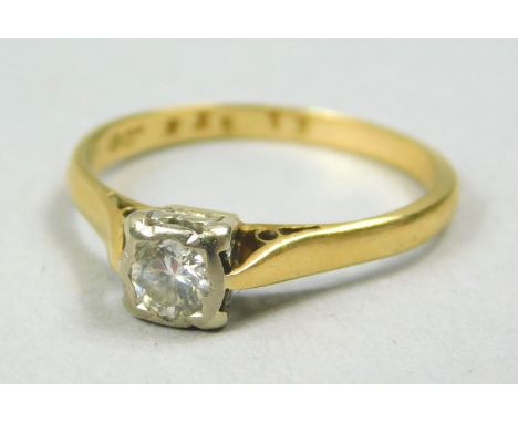 An 18ct gold diamond solitaire ring, set with round brilliant cut stone, in a plat rub over setting, approx 0.14cts, with pie