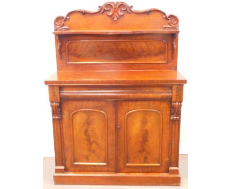 A Victorian mahogany chiffonier, the raised back carved with scrolls above a shelf and an arched panel, the base with a singl