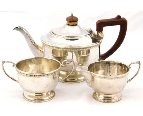 A George V silver three piece tea set, of baluster form embossed with a band of harebells, comprising teapot, cream jug and s