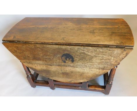 An 18thC oak gate leg table, the oval top on turned supports with flat stretcher, 102cm wide