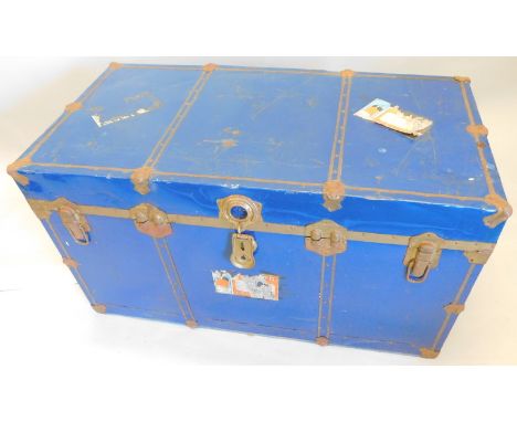 A blue painted tin trunk, with Cunard labels.