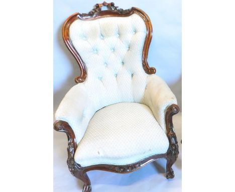 A Victorian mahogany show frame armchair, with a button back, padded arms and seat, on cabriole legs with leaf carved arm sup