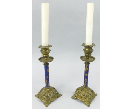 A pair of late 19thC gilt metal and enamel candlesticks, each decorated in gilt with flowers and leaves, on a pierced base, u