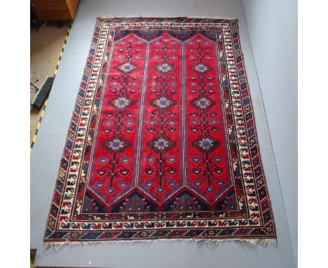 A red-ground Persian carpet. 293x198cm.Some fraying to edges. Some moth damage. 