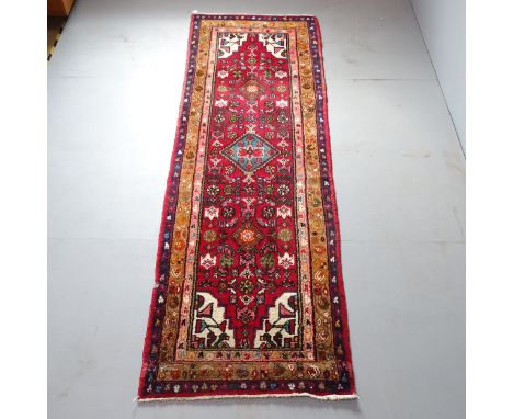 An Iranian red-ground runner. 265x85cm.Pile loss to one edge. No fringe. 