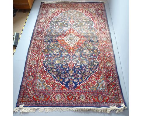 A red and blue-ground Persian Keshan carpet. 327x203cm.Faded. Would benefit from a clean. 