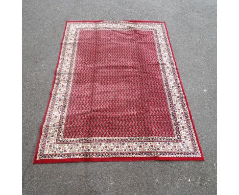 A red-ground Belgian machine-made carpet with oriental design. 334x236cm. 