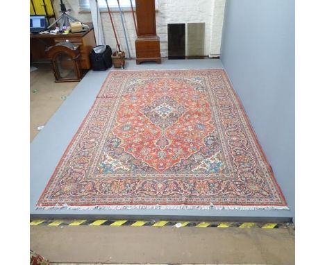 A red-ground Kashan carpet. 305x203cm 