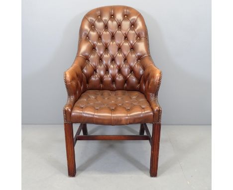 A modern studded button-back faux-leather upholstered desk chair. 