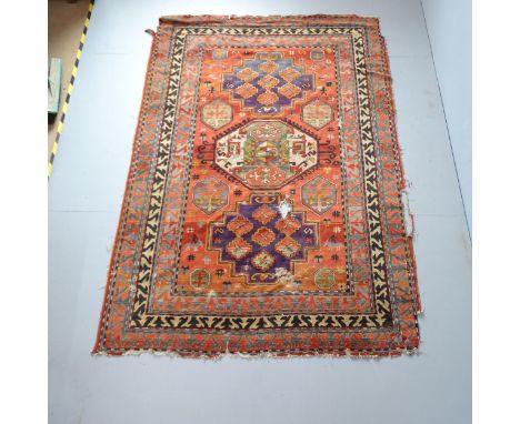 A red-ground Afghan carpet. 240x166cm.Several holes to central medallion. Edges are damaged. In need of repair and clean. 