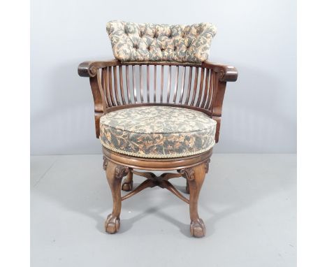 A Victorian mahogany revolving bow arm office chair, button back upholstered, raised on cabriole legs and claw and ball feet.