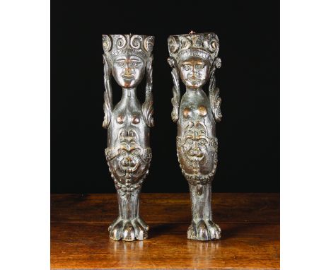 A Pair of 17th Century English Oak Figural Supports carved in the round as caryatid monopods. The female figures wearing volu