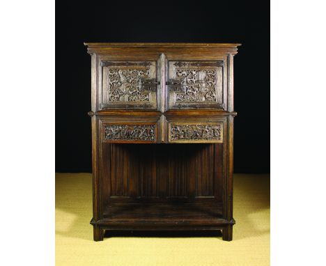 A 19th Century Gothic Revival Dressoir. The richly carved cupboard doors hung on long shaped strap hinges. The two drawers ca