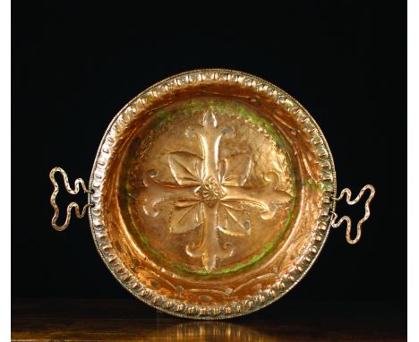A Large 17th Century Florentine Copper Basin with repoussé decoration. The centre emblazoned with a cruciform motif, the side