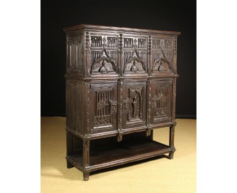 A 19th Century Gothic Revival Oak Cupboard.  The top section having linenfold panelled doors to the sides and three front pan