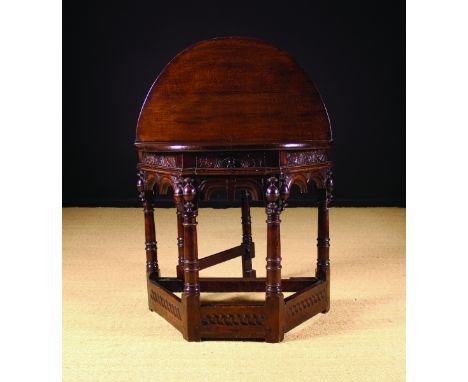 A 17th Century Oak Credence Table. The fold-over demi-lune top above a canted base with a lunette carved frieze housing a dra